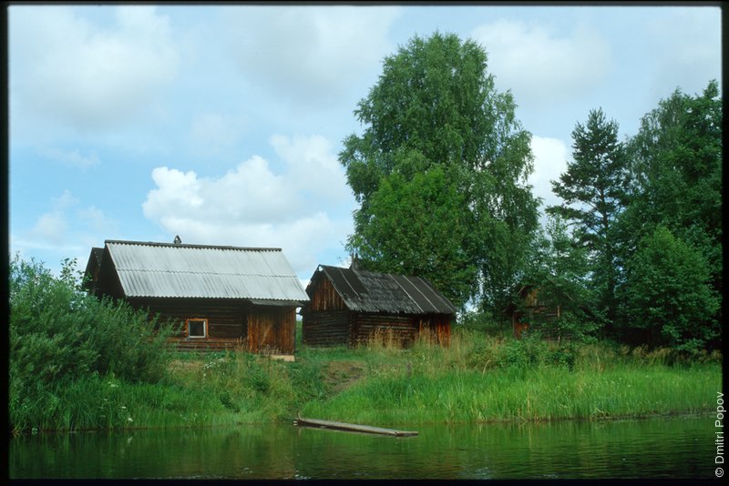 Деревянные строения на берегу реки Великой